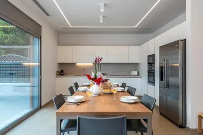 a kitchen and dining room with a wooden table and chairs at Ialyssos Charme Villa in Ialyssos