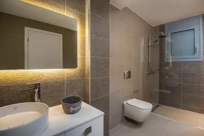 a bathroom with a sink and a toilet and a mirror at Ialyssos Charme Villa in Ialyssos