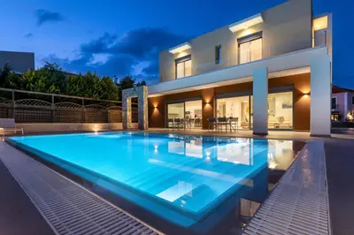a large swimming pool in front of a house at Ialyssos Charme Villa in Ialyssos