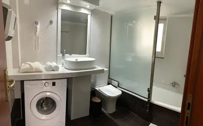 a bathroom with a sink and a washing machine at A&B Ialysos villas and apartments in Ialyssos