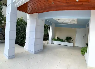 a large patio with white columns and a wooden ceiling at A&B Ialysos villas and apartments in Ialyssos