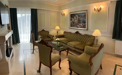 a living room with a couch and chairs and a table at A&B Ialysos villas and apartments in Ialyssos