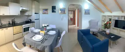 a kitchen and living room with a table and a blue chair at A&B Ialysos villas and apartments in Ialyssos