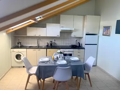 a kitchen with a table and chairs in a kitchen at A&B Ialysos villas and apartments in Ialyssos