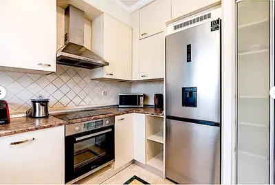 a kitchen with white cabinets and a stainless steel refrigerator at A&B Ialysos villas and apartments in Ialyssos