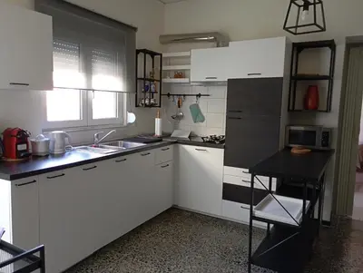 a small kitchen with white cabinets and a sink at MARY'S APARTMENT in Paradissi in Paradeísion