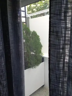 a view of a garden from a window with curtains at MARY'S APARTMENT in Paradissi in Paradeísion