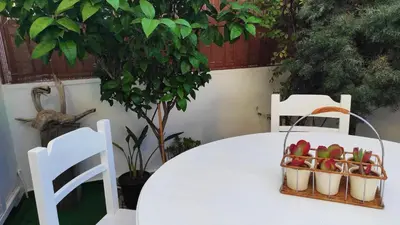 a white table with two chairs and a table with fruit in baskets at MARY'S APARTMENT in Paradissi in Paradeísion
