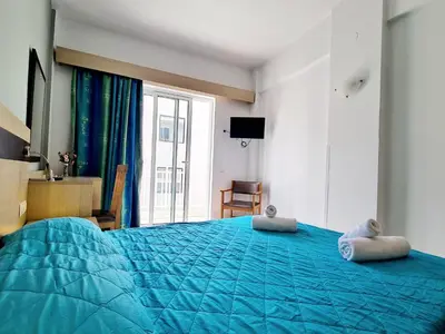 a bedroom with a blue bed with two pillows on it at G92 City Hotel in Rhodes Town