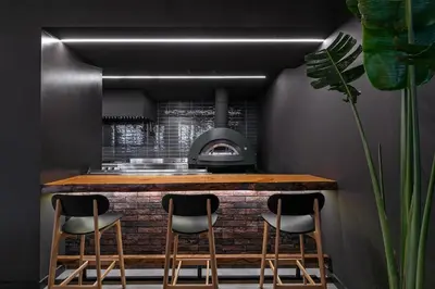 a kitchen with a counter with stools and a stove at Amada Colossos Resort in Faliraki