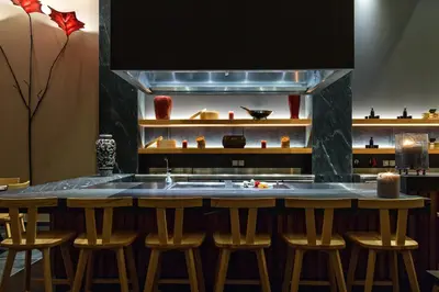 a kitchen with a bar with stools and a sink at Amada Colossos Resort in Faliraki