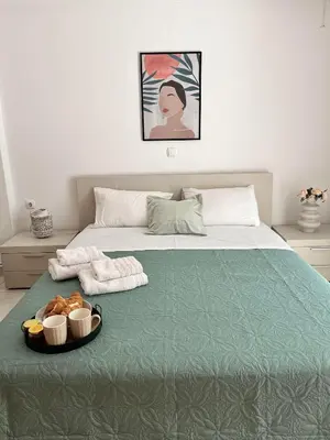 a bed with two towels and a tray of food on it at Garden House with sea view in Faliraki