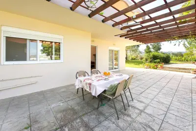 a dining room with a table and chairs on a patio at Garden House with sea view in Faliraki