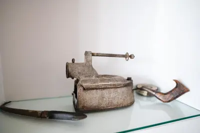 an old iron sitting on top of a glass table at Irini's house afandou in Afantou