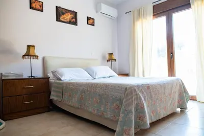 a bedroom with a bed and a large window at Irini's house afandou in Afantou
