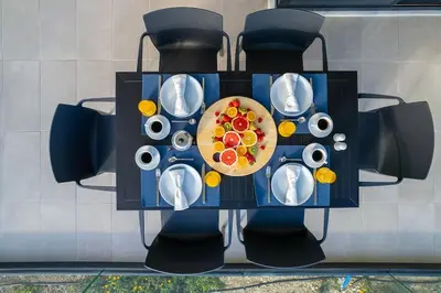 a table with a plate of food on it at Maison Du Jardin 2-Bedroom Apartment Private Outdoor Jacuzzi in Rhodes Town