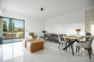 a living room with a couch and a table and chairs at Maison Du Jardin 2-Bedroom Apartment Private Outdoor Jacuzzi in Rhodes Town