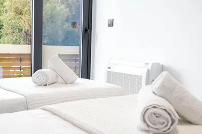 a bedroom with two beds with white sheets and a window at Maison Du Jardin 2-Bedroom Apartment Private Outdoor Jacuzzi in Rhodes Town