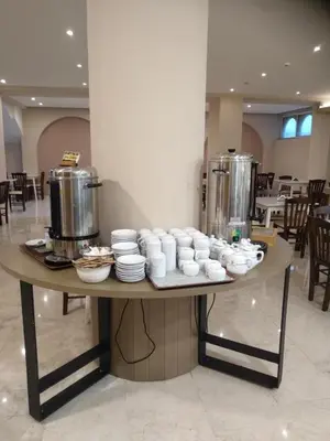 a table with cups and dishes on it in a restaurant at Hotel Africa in Rhodes Town