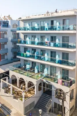an apartment building with blue chairs on the balconies at Hotel Africa in Rhodes Town