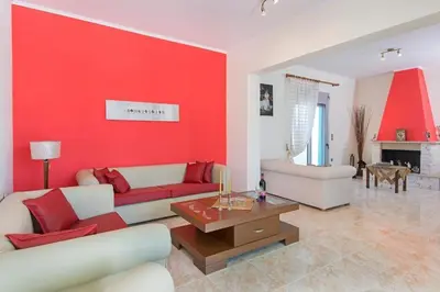 a living room with a red accent wall at Pearl Villas Apolakkia - Beach Front Villas with Private Pool in Apolakkiá