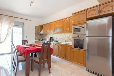 a kitchen with a table with a red table cloth at Pearl Villas Apolakkia - Beach Front Villas with Private Pool in Apolakkiá
