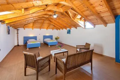 a living room with wooden ceilings and a table and chairs at Pearl Villas Apolakkia - Beach Front Villas with Private Pool in Apolakkiá