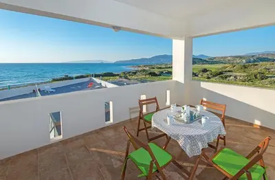 a dining room with a table and chairs and the ocean at Pearl Villas Apolakkia - Beach Front Villas with Private Pool in Apolakkiá