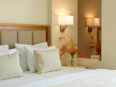 a bedroom with a bed with pillows and a vase of flowers at Apollo Beach in Faliraki