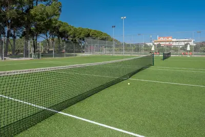 a tennis court with a net on a green court at Apollo Beach in Faliraki