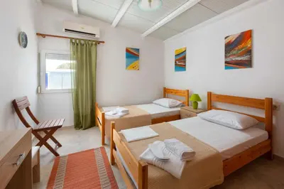 a bedroom with two beds and a desk at Beach Pearl - Beach Front House with Private Pool in Gennadi