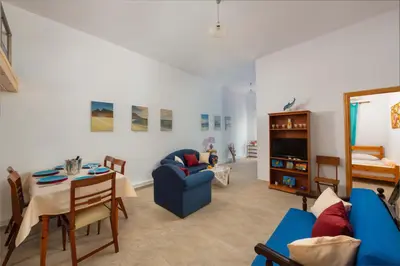 a living room with a blue couch and a table at Beach Pearl - Beach Front House with Private Pool in Gennadi