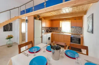 a kitchen with a table with blue plates on it at Beach Pearl - Beach Front House with Private Pool in Gennadi