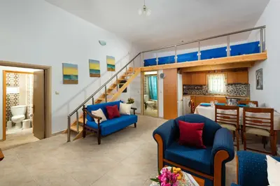 a living room with blue chairs and a loft bed at Beach Pearl - Beach Front House with Private Pool in Gennadi