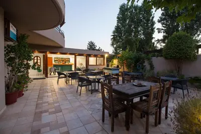 a patio with tables and chairs and a restaurant at John Mary in Faliraki
