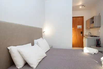 a bedroom with a bed with white pillows at John Mary in Faliraki