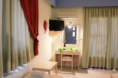 a room with a table and a desk with a mirror at John Mary in Faliraki