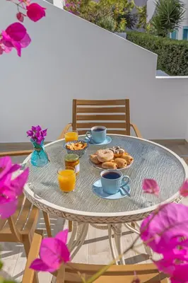 a table with cups of coffee and food on it at Haraki Mare Studios beach front in Haraki
