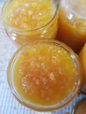 three jars of orange jam sitting on a table at Haraki Mare Studios beach front in Haraki