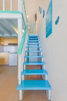 a staircase with blue steps in a house at Haraki Mare Studios beach front in Haraki