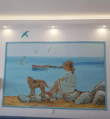a painting of a girl and a dog on a wall at Haraki Mare Studios beach front in Haraki