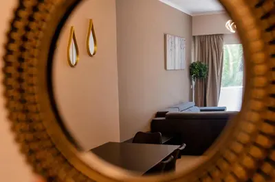 a living room with a couch and a table in a mirror at Rhodes Island Elli Beach Apartments in Rhodes Town