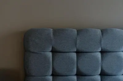 a blue couch sitting next to a wall at Rhodes Island Elli Beach Apartments in Rhodes Town