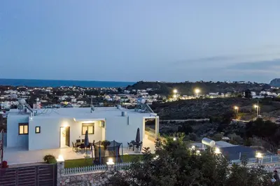 a house with a view of a city at night at Sebastian Villas in Afantou