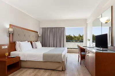 a hotel room with a bed and a desk and a television at Best Western Plus Hotel Plaza in Rhodes Town