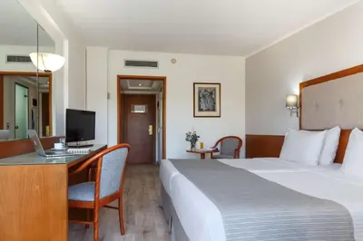 a hotel room with a bed and a desk with a computer at Best Western Plus Hotel Plaza in Rhodes Town