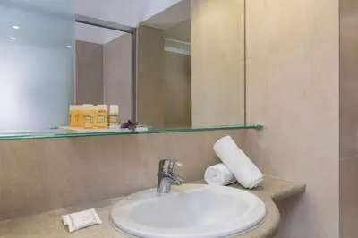 a bathroom with a sink and a mirror at Best Western Plus Hotel Plaza in Rhodes Town
