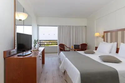 a hotel room with two beds and a flat screen tv at Best Western Plus Hotel Plaza in Rhodes Town
