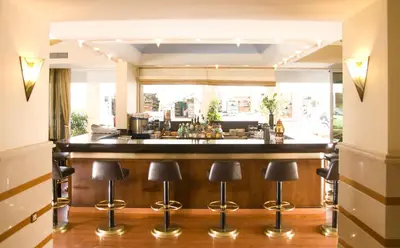 a bar with black stools in front of a counter at Best Western Plus Hotel Plaza in Rhodes Town