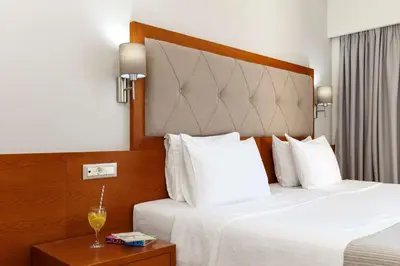 a hotel room with two beds and a drink on a table at Best Western Plus Hotel Plaza in Rhodes Town